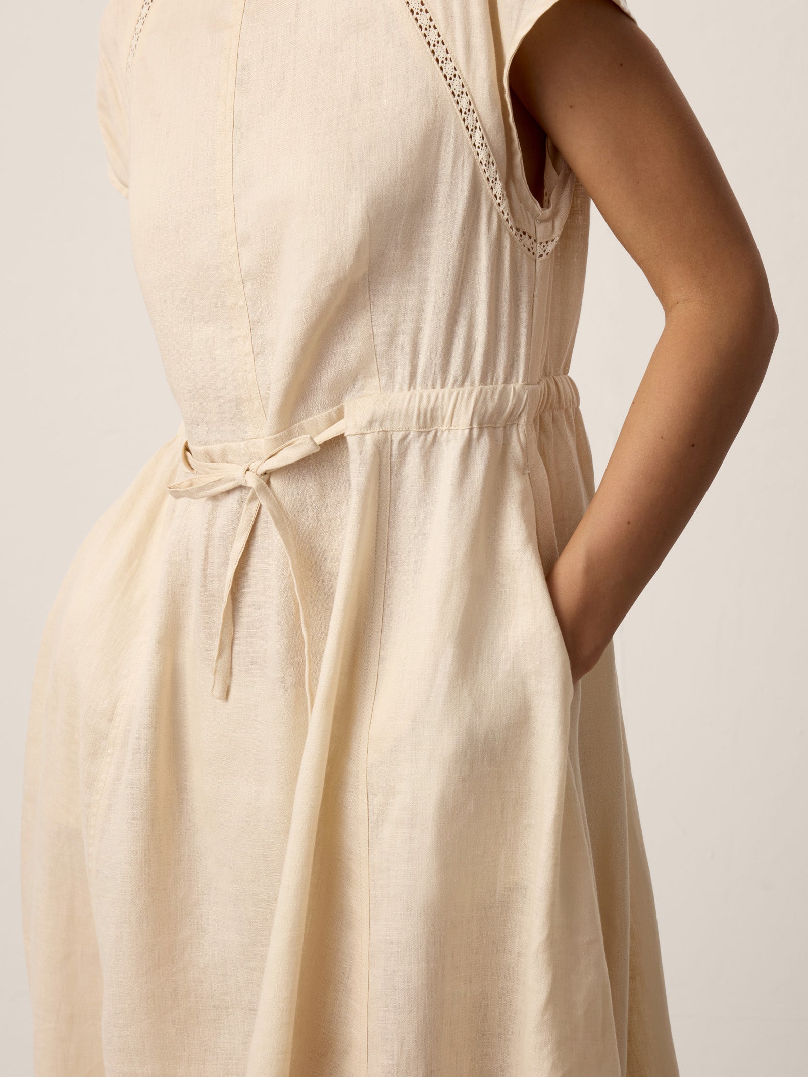 Beige dress with a belt on a plain background