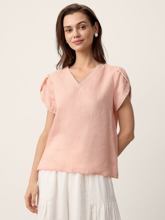 Woman wearing a pink blouse with a plain background