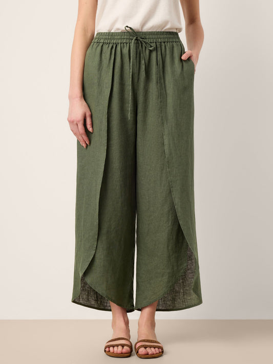 Person wearing green wide-leg pants on a plain background