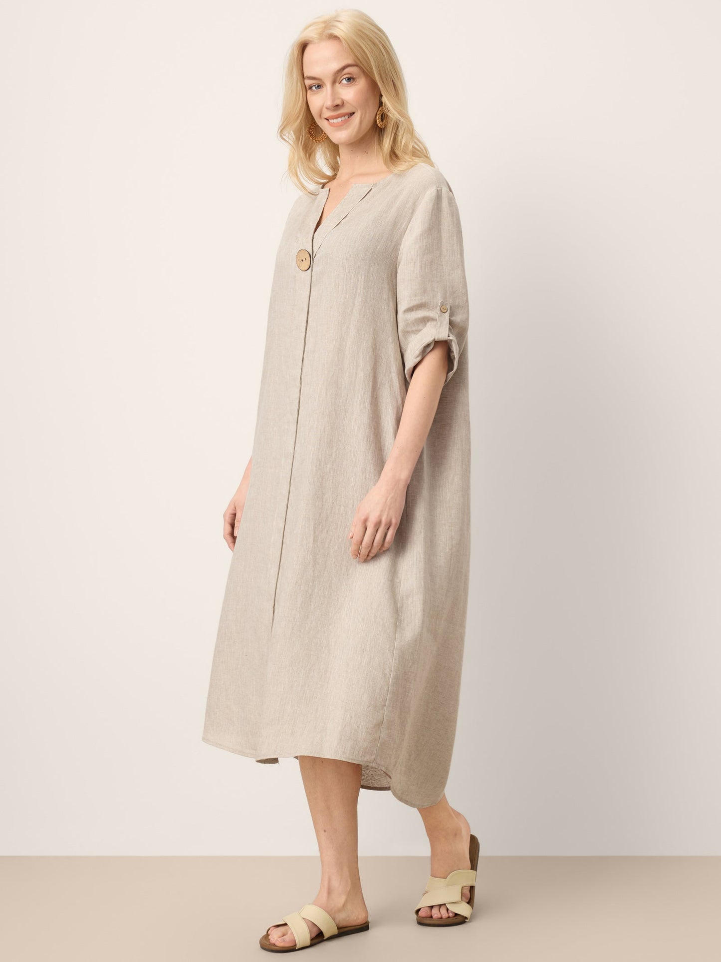 Woman wearing a beige dress on a plain background