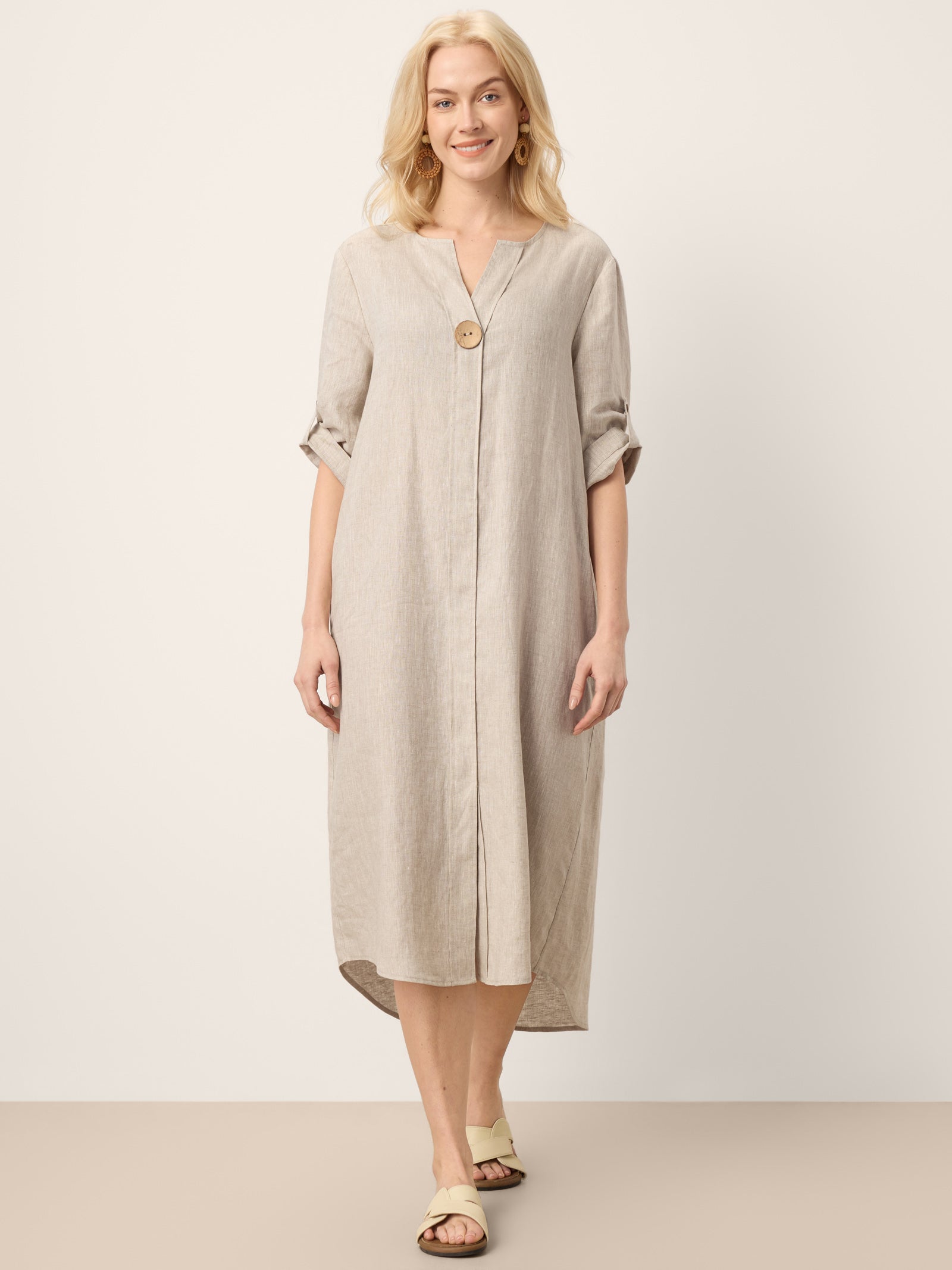 Woman wearing a beige dress with a plain background