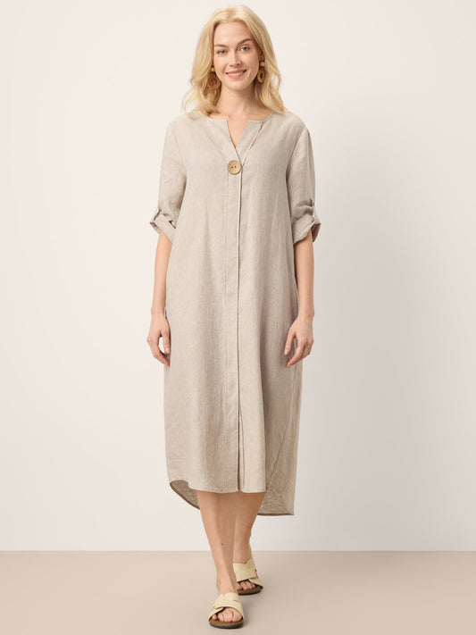 Woman wearing a beige dress with a plain background