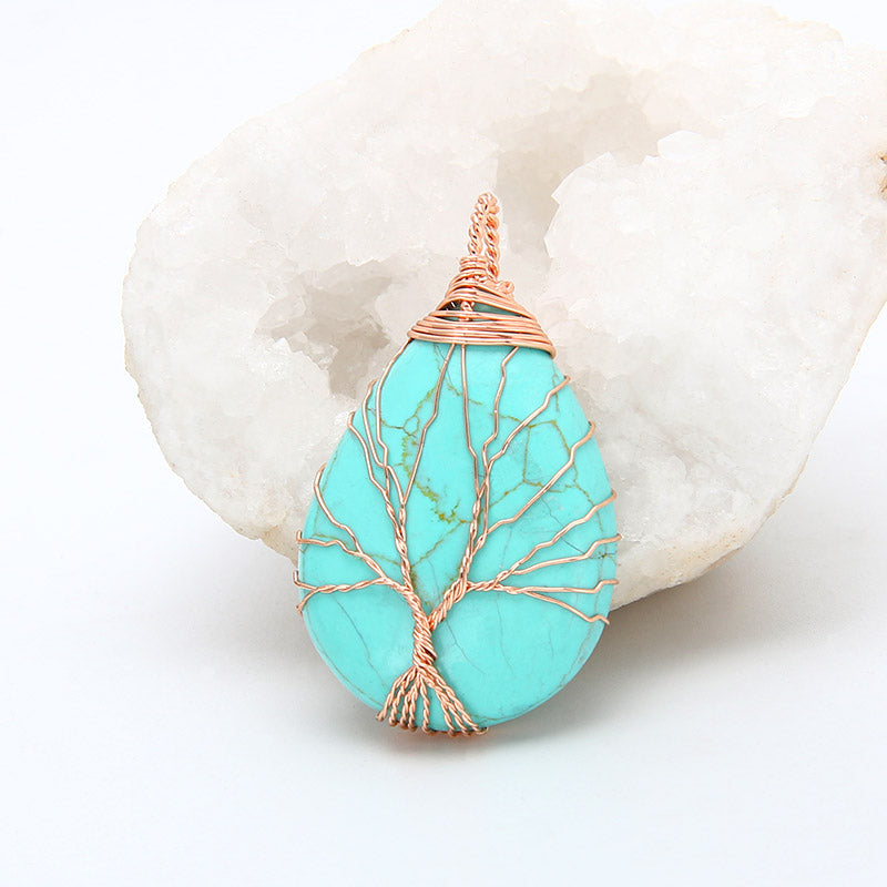 Turquoise stone pendant with rose gold wire wrapping on a white background