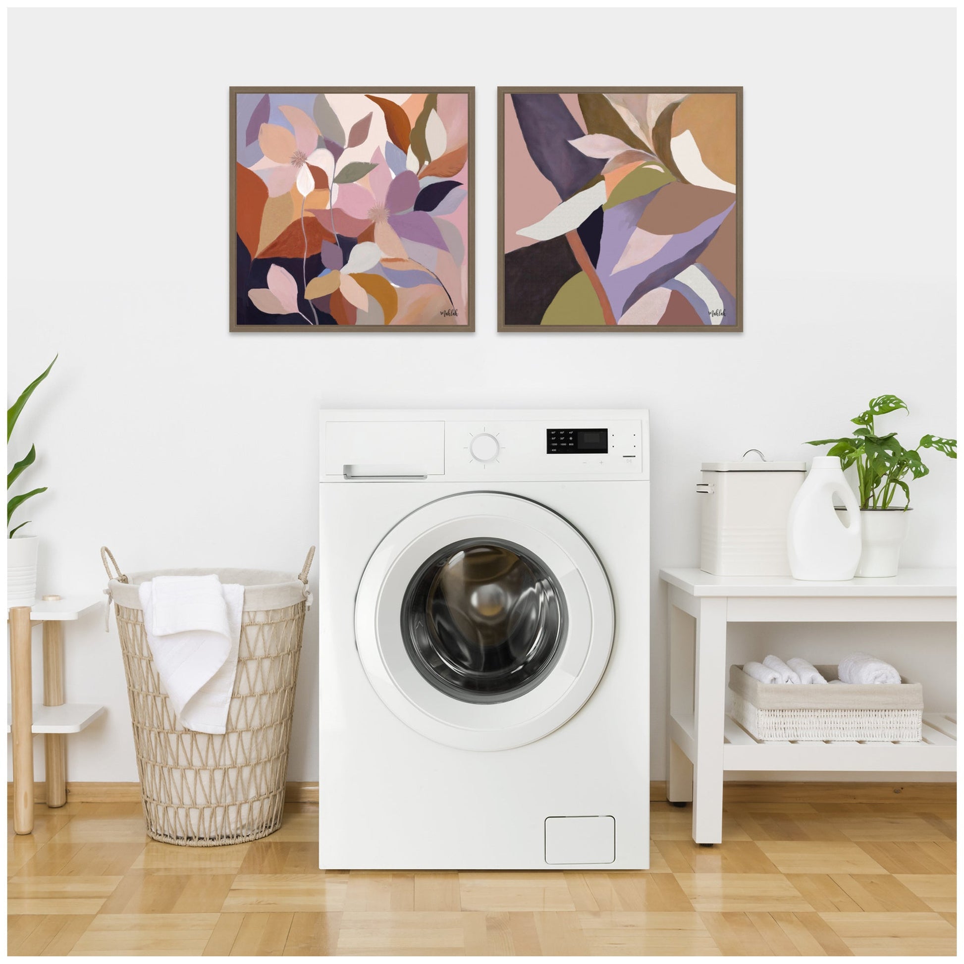 Modern laundry room with a white washing machine, abstract art on the wall, and wooden flooring.