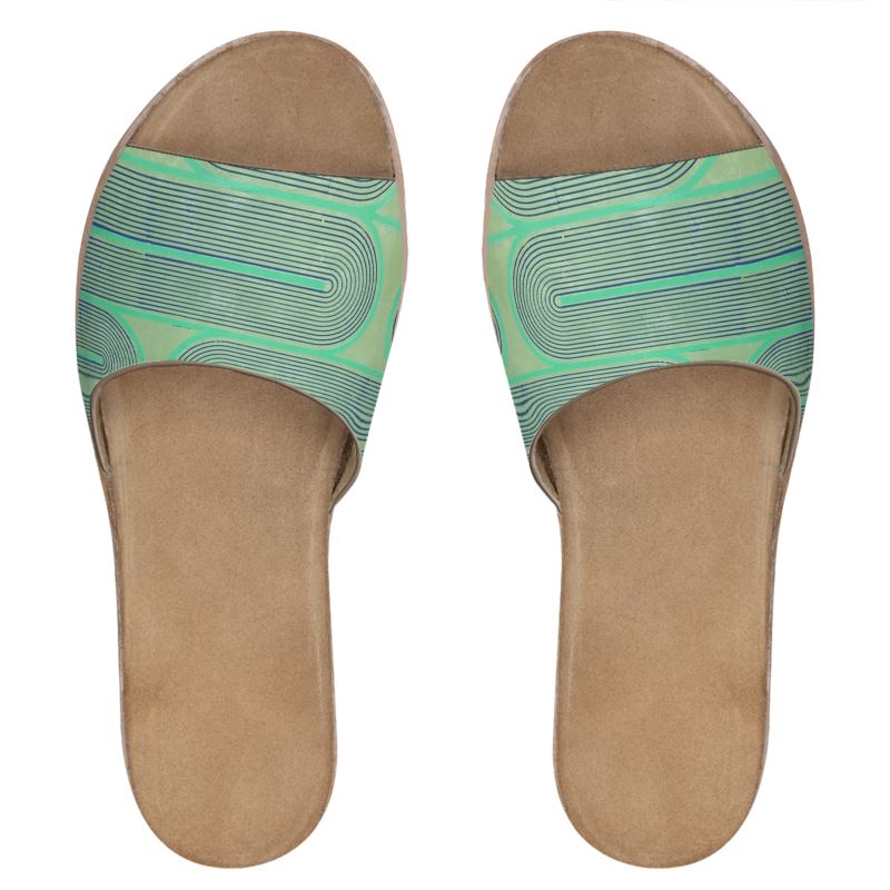Pair of tan sandals with green patterned straps on a white background