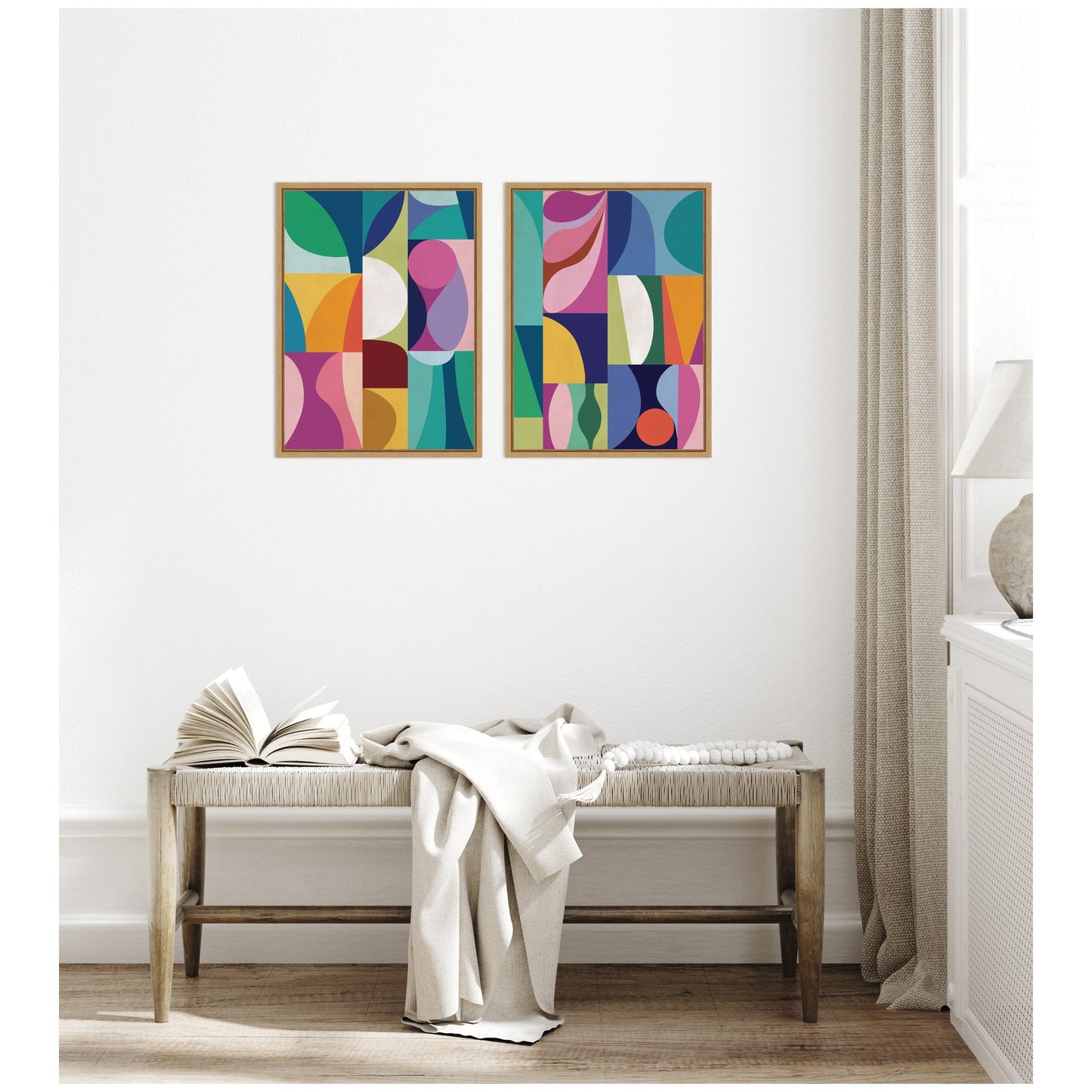 Two colorful abstract paintings on a white wall above a wooden bench.