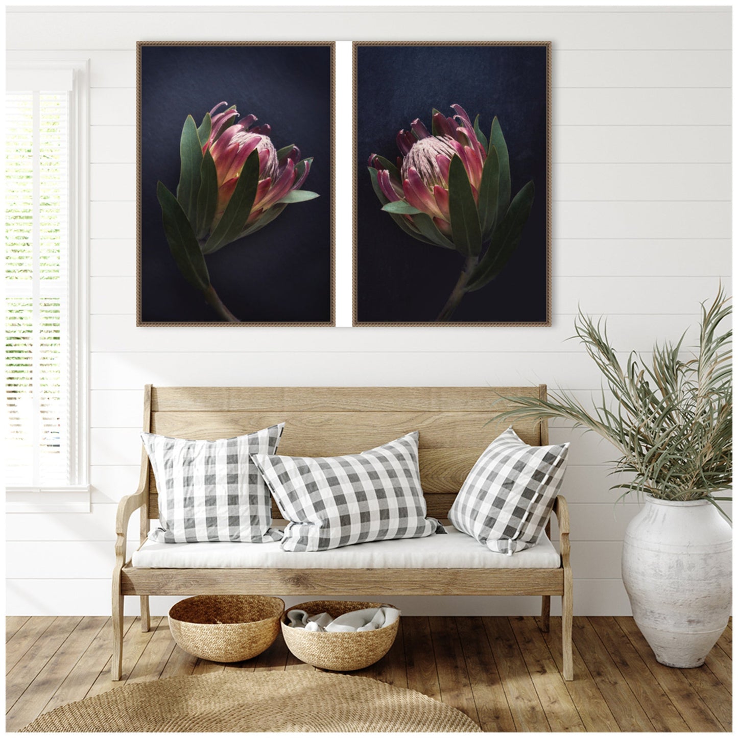 Wooden bench with checkered pillows, wicker baskets, and a vase of flowers in a room with framed floral art on the wall.