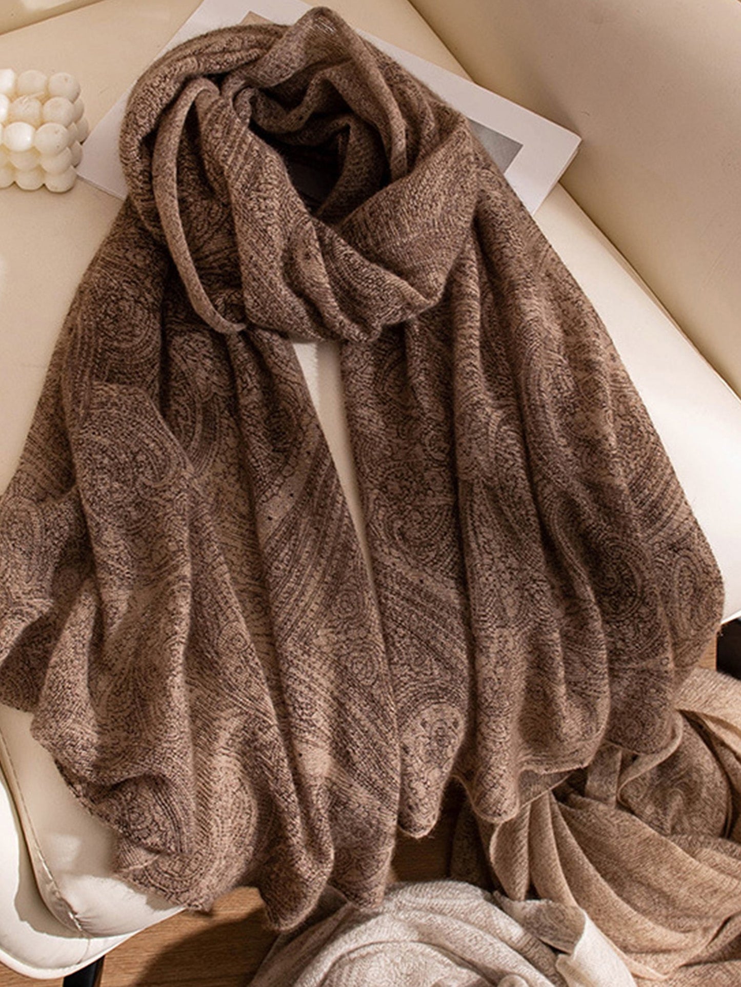 Brown textured towel draped over a white surface