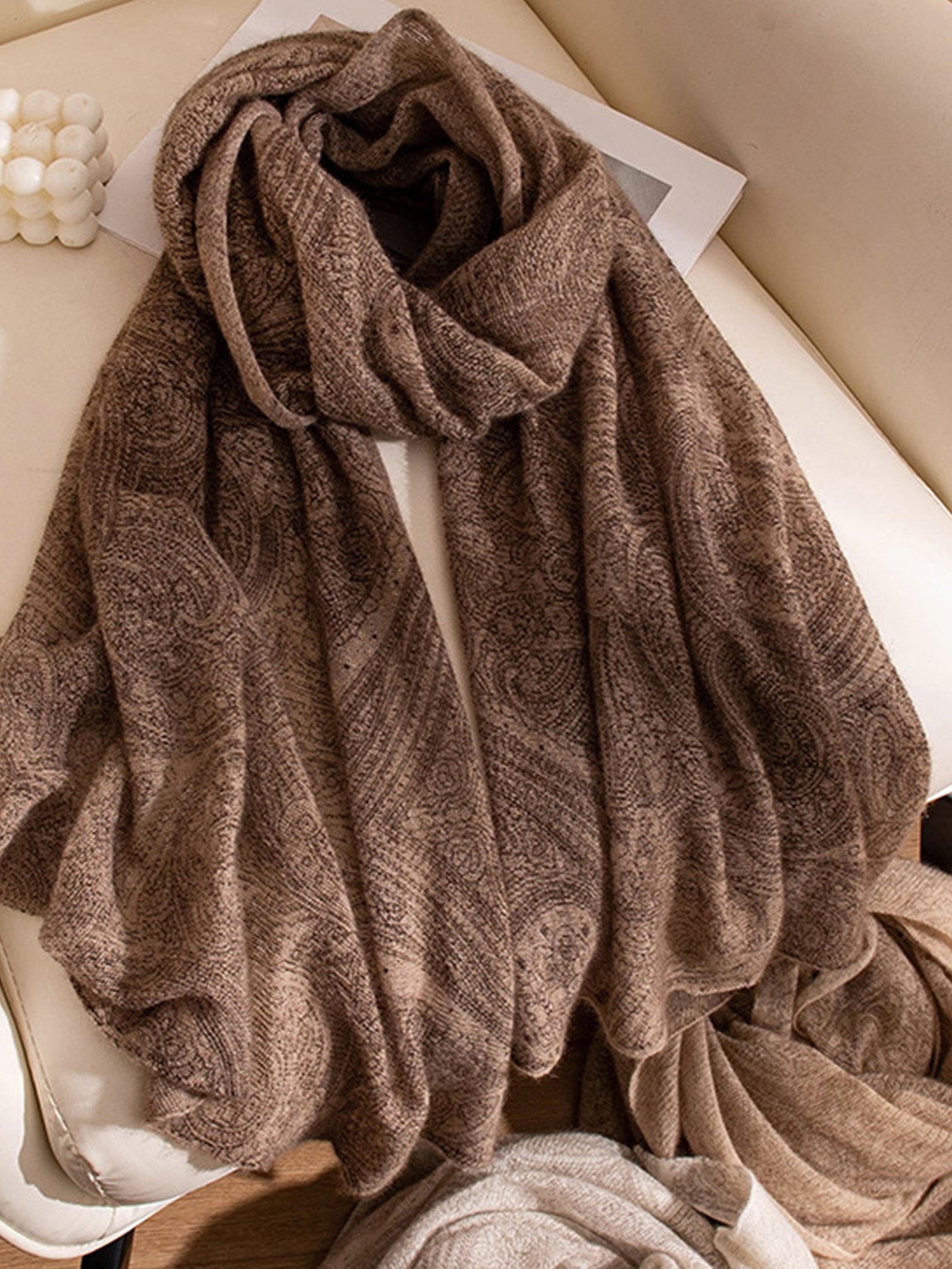 Brown textured towel draped over a white surface