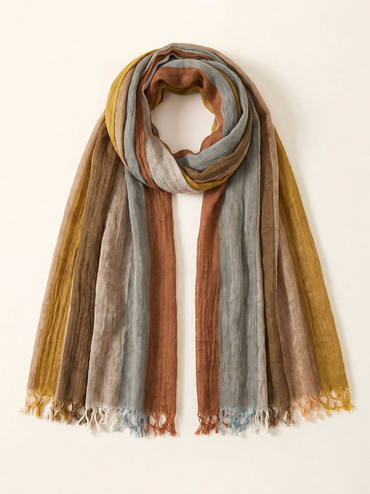 A lightweight scarf with a striped pattern in mustard yellow, dusty blue, terracotta, and taupe, featuring fringed edges, displayed against a plain off-white background.