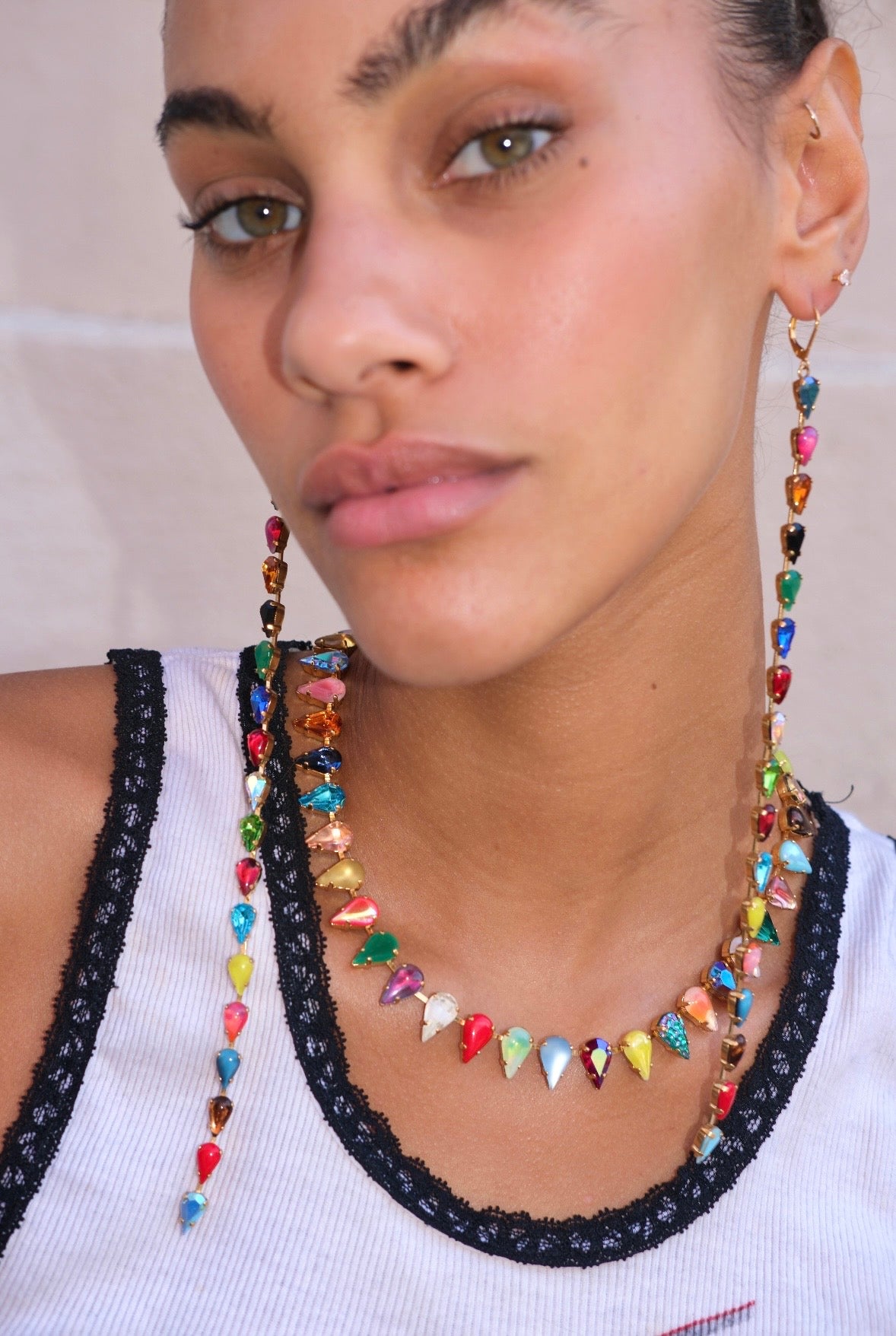 Close-up of a person wearing a colorful beaded necklace and earrings.