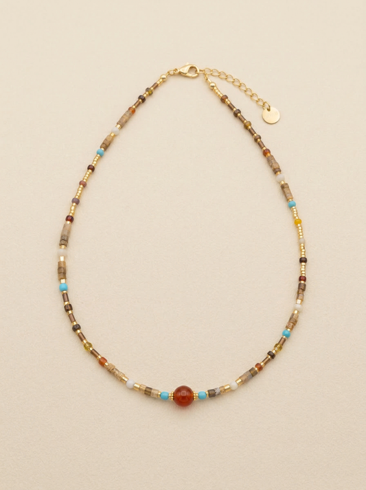 Beaded necklace with a large central bead on a beige background