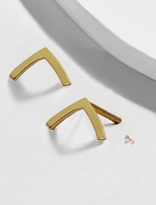 Gold V-shaped earrings on a light gray background