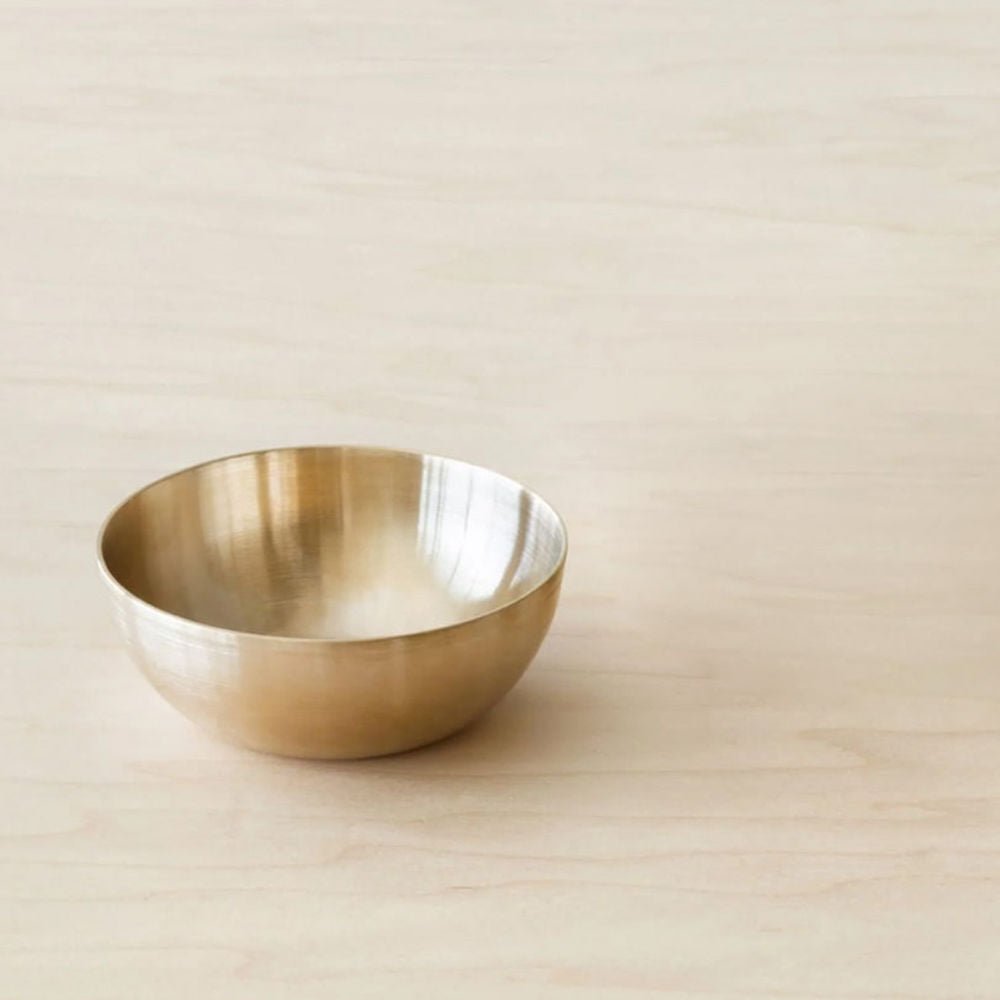 Gold bowl on a beige background