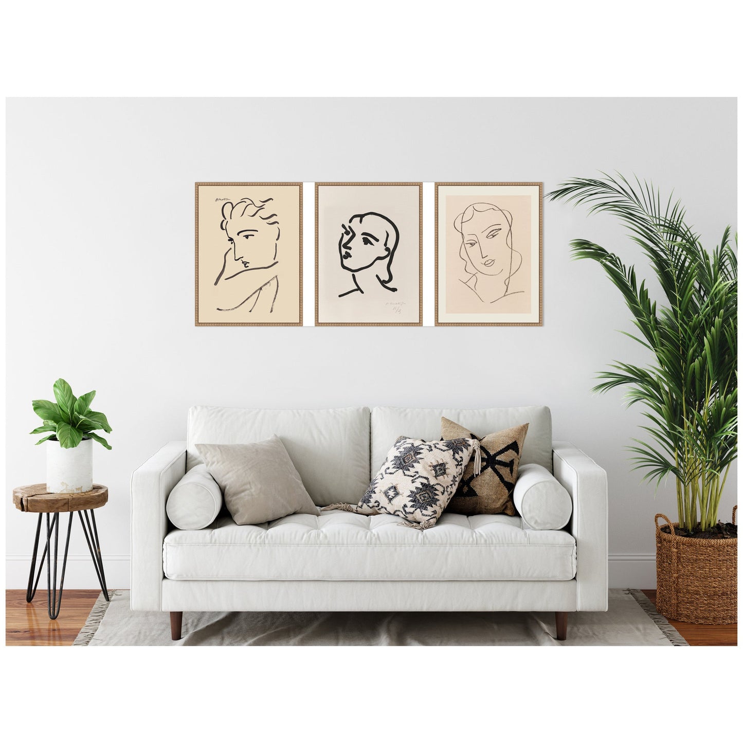 White sofa with decorative pillows in a living room setting with wall art and plants.