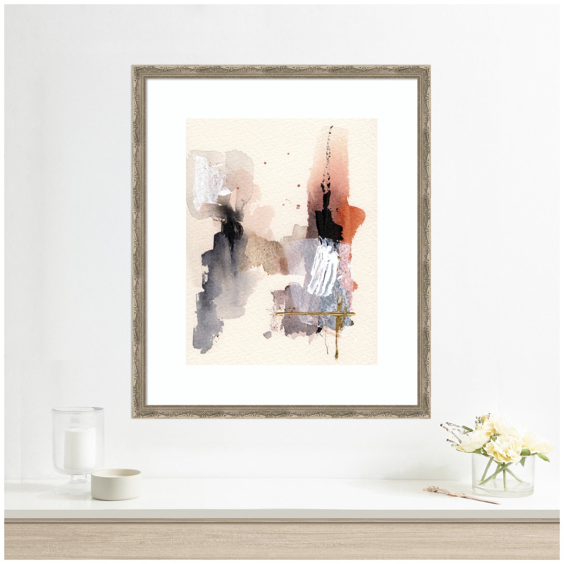 Framed abstract art print on a white wall with decorative items below.