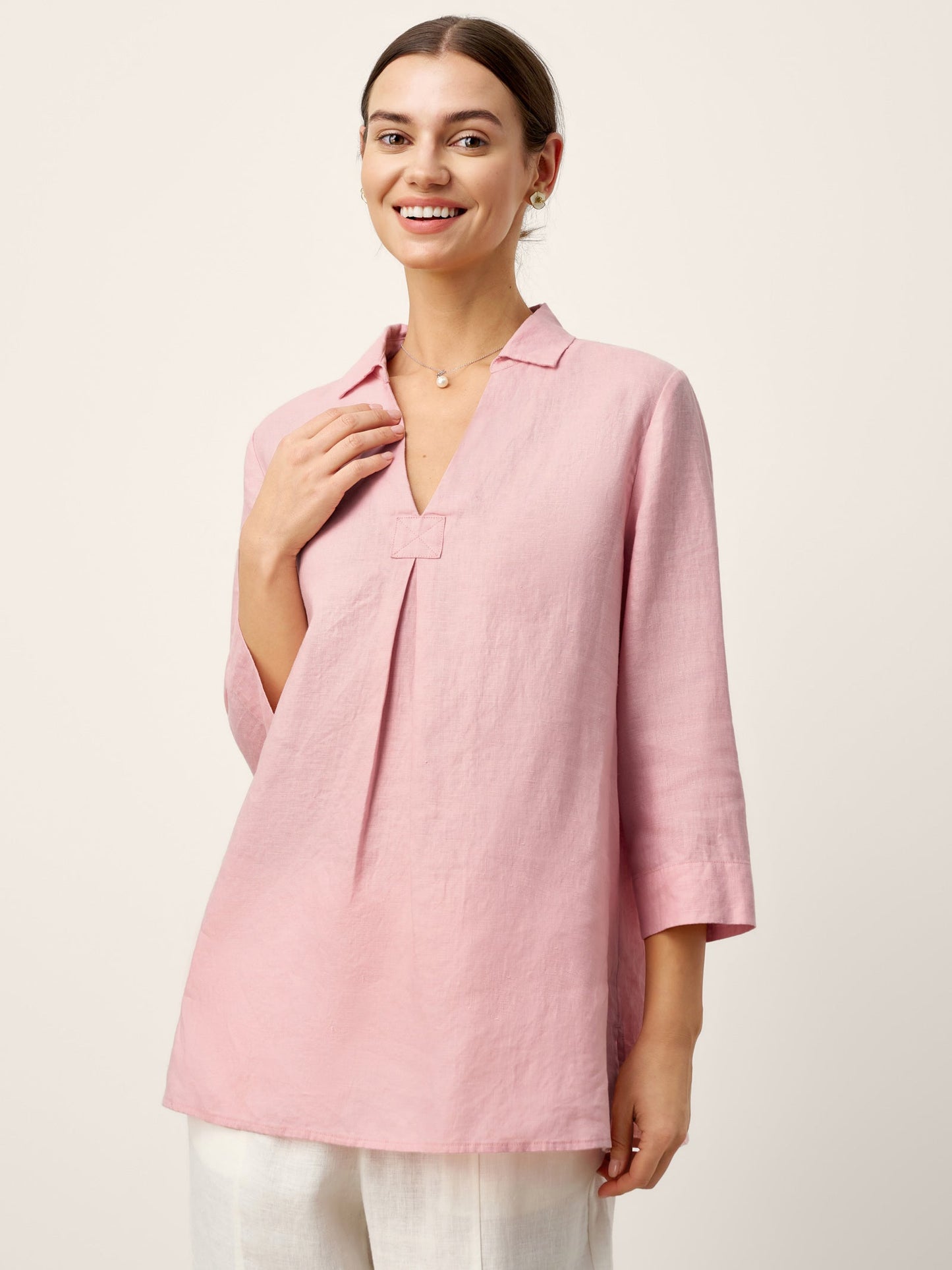 Woman wearing a pink blouse against a white background