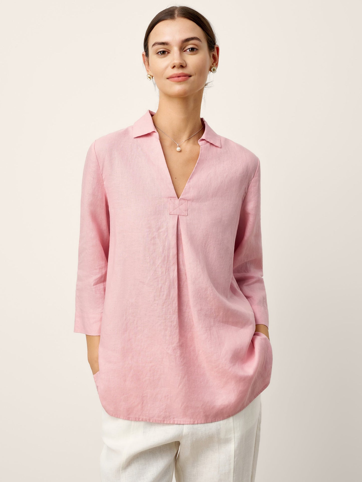 Woman wearing a pink blouse against a plain background