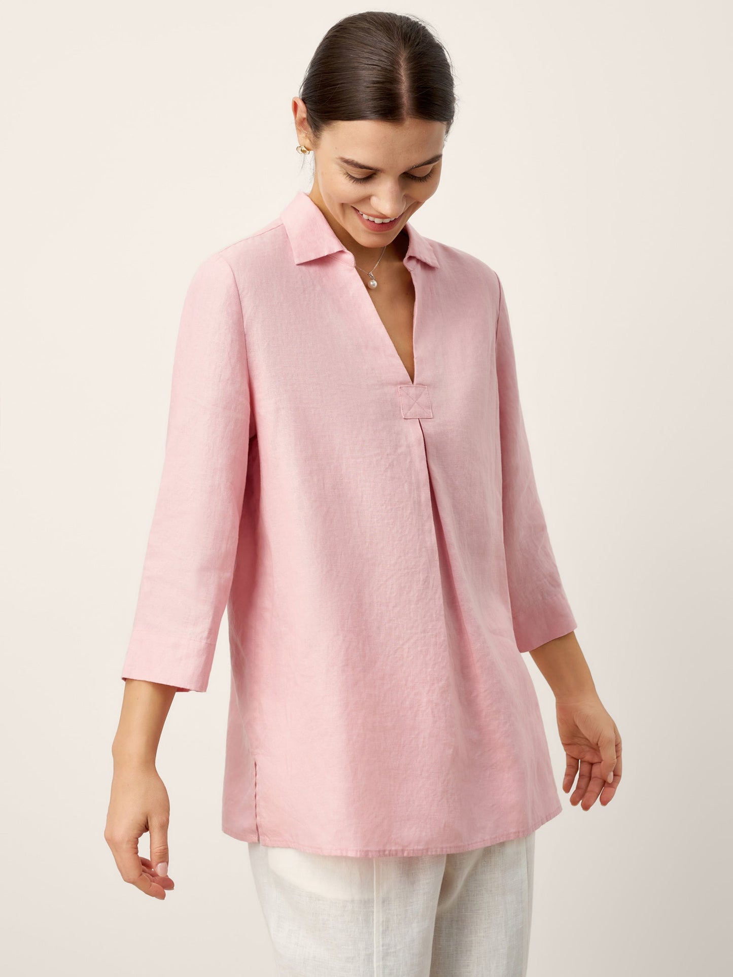 Woman wearing a pink blouse against a light background