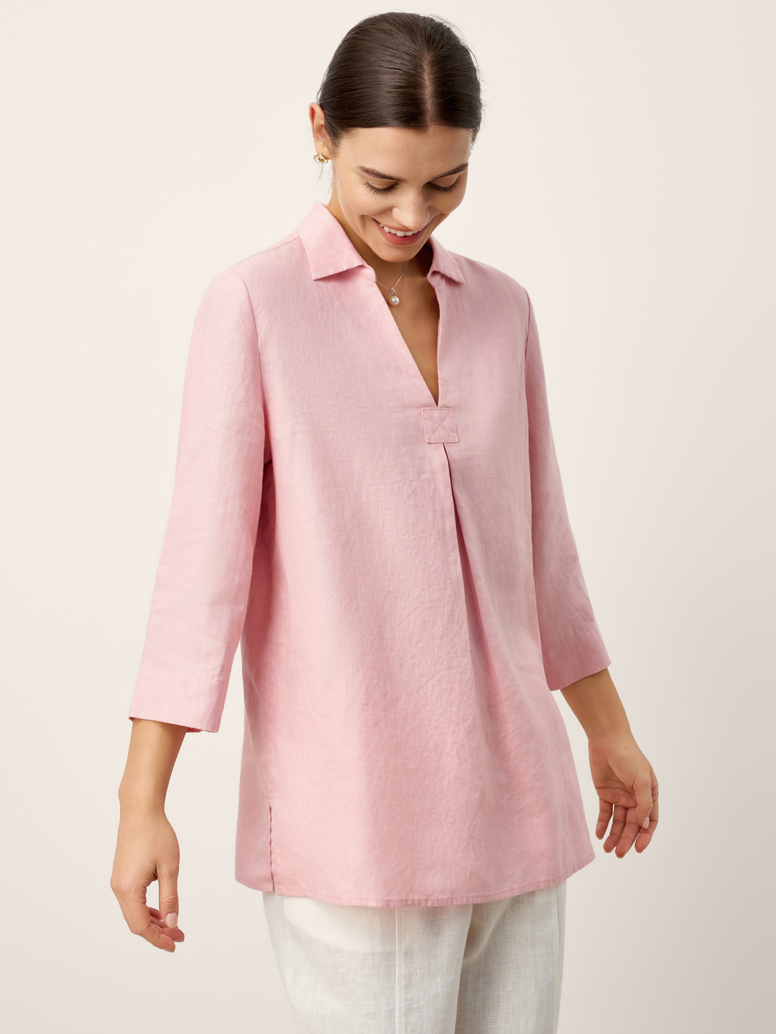 Woman wearing a pink blouse against a light background