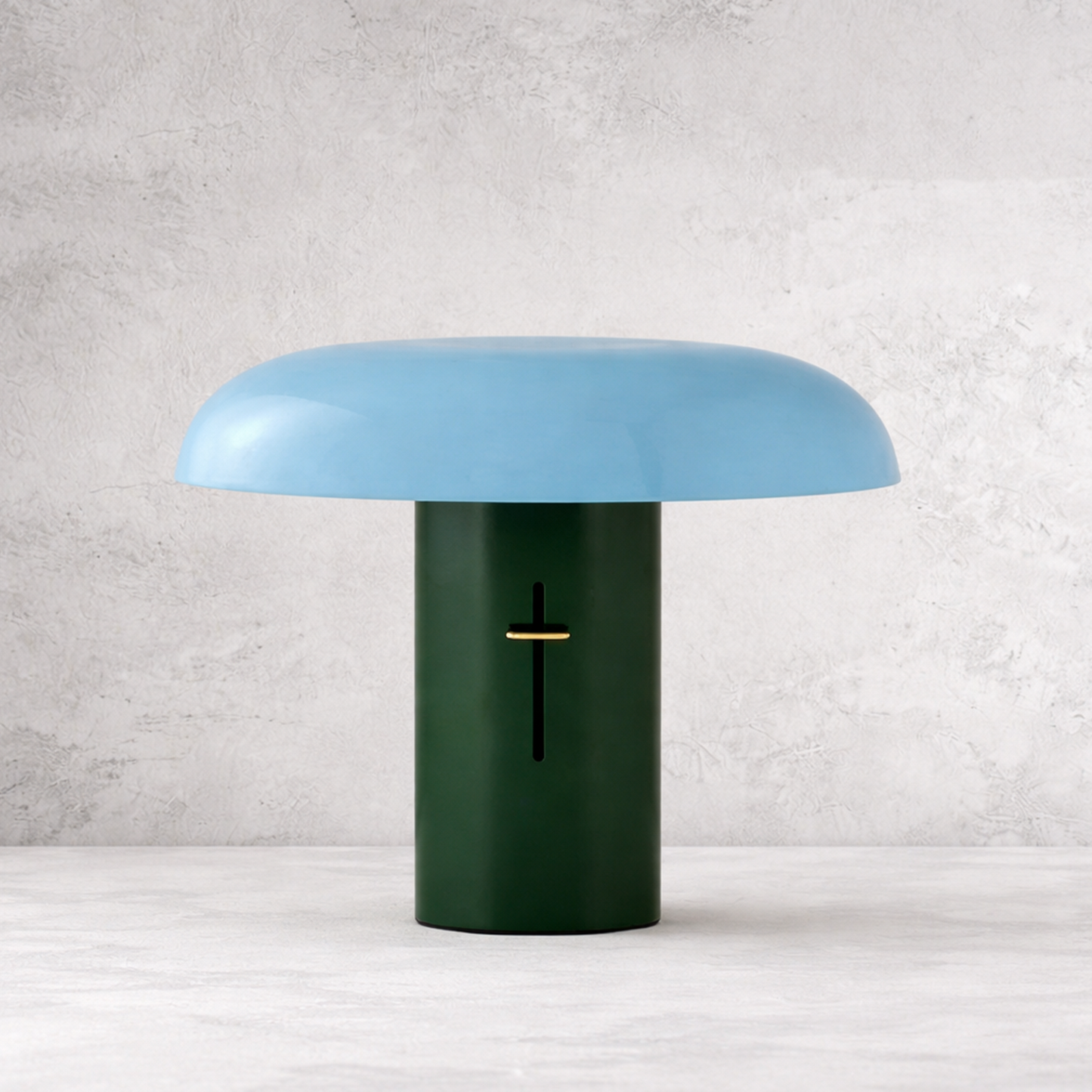 Table lamp with a blue shade and green base on a white surface with a light gray textured background