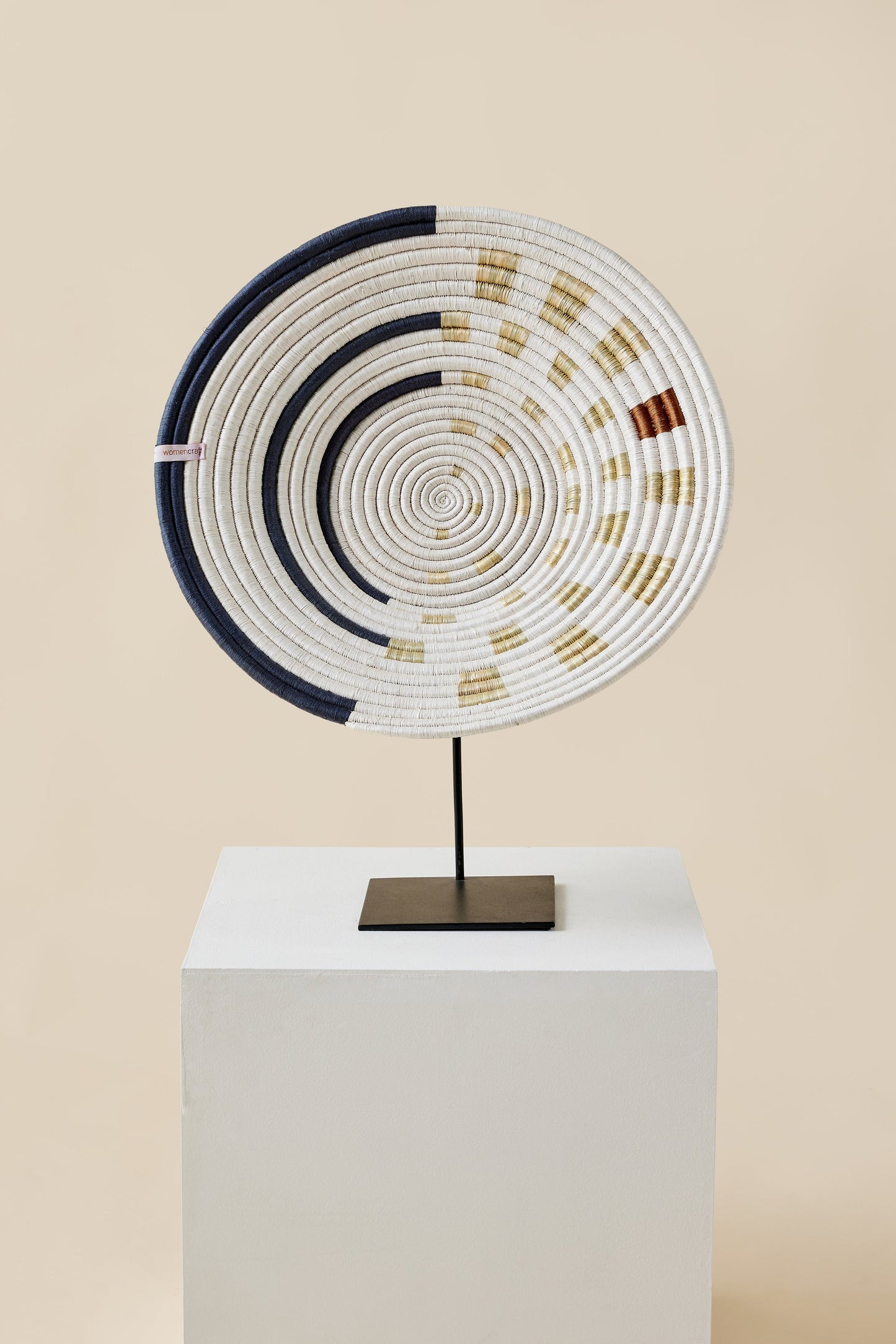 Decorative circular sculpture with concentric patterns on a beige background