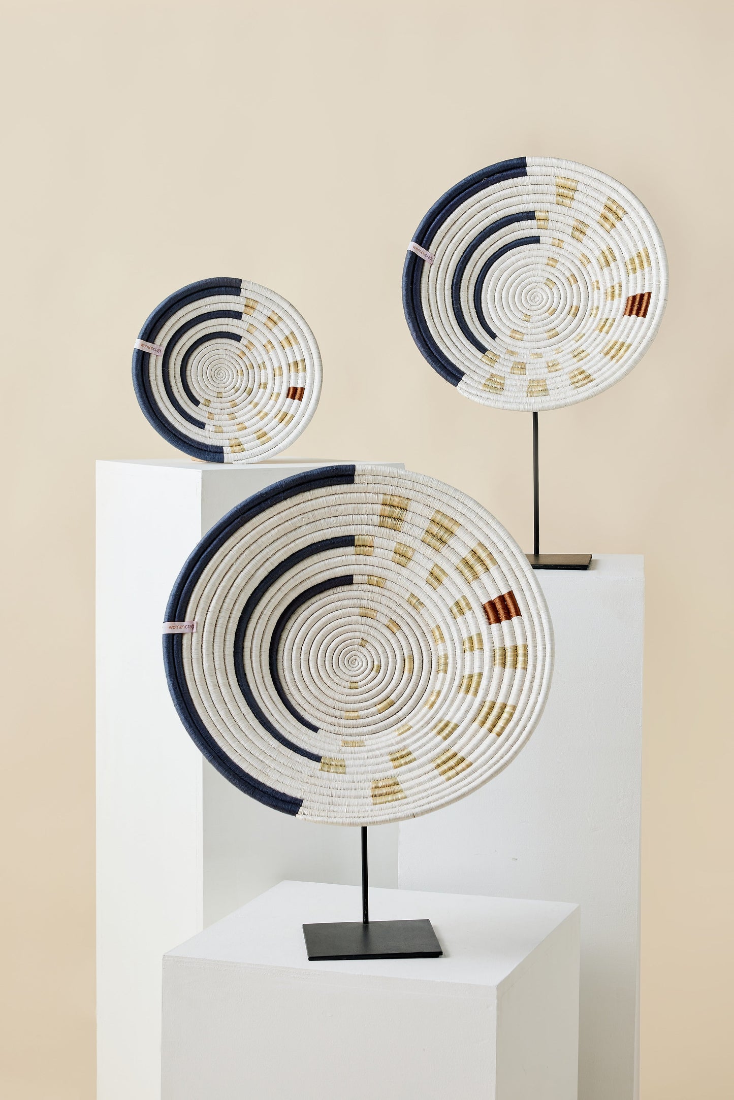 Decorative circular sculptures with spiral patterns on a beige background