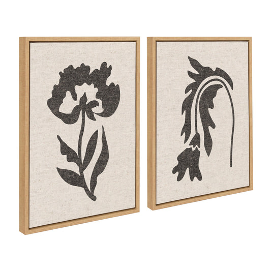 Two framed black floral silhouettes on beige backgrounds with wooden frames.