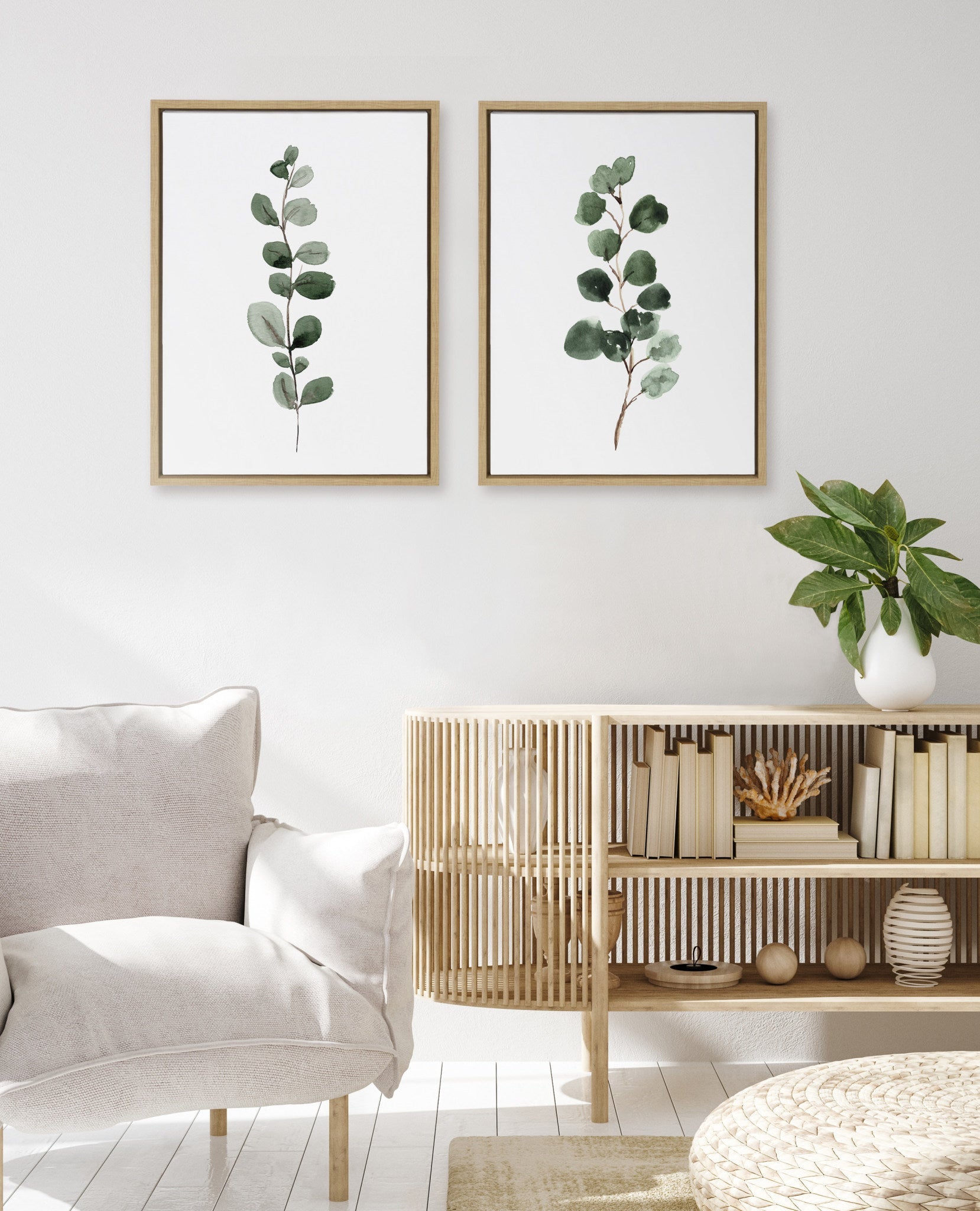 Modern living room with eucalyptus prints on the wall, a sofa, and a wooden side table.